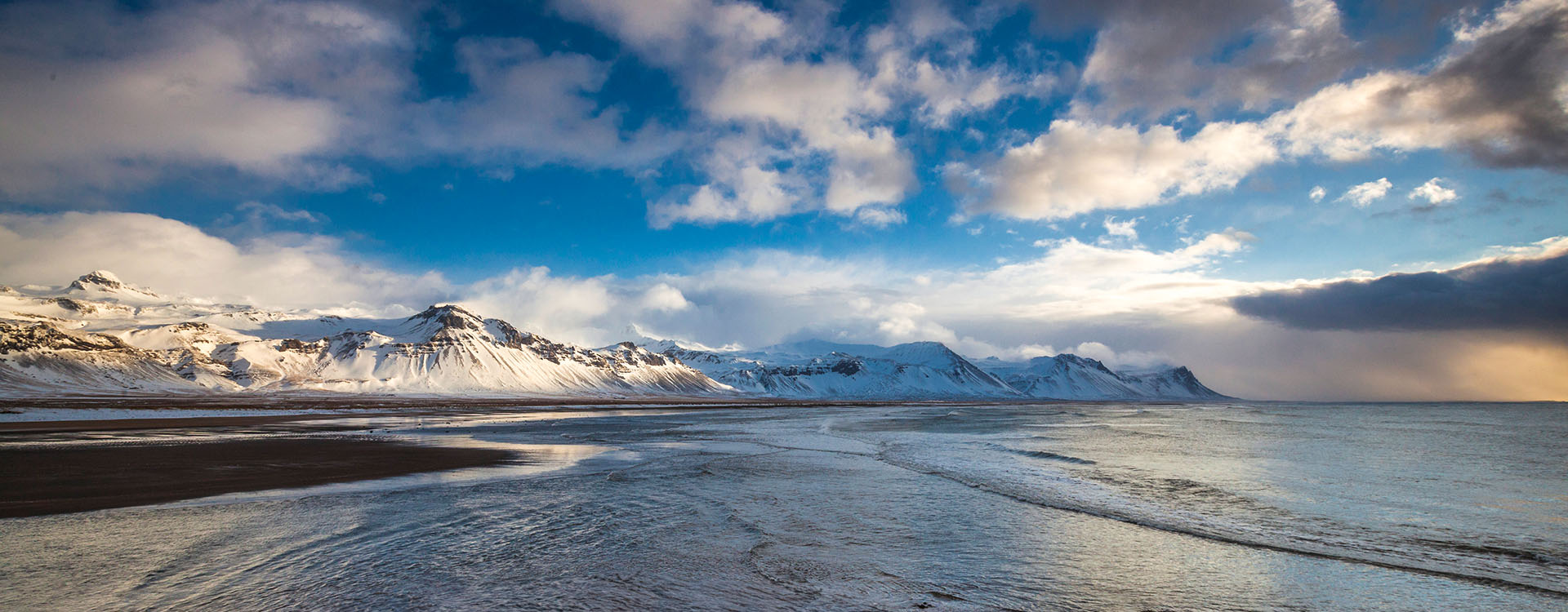 Islandreisen Islandurlaub schneebedeckte Berge bei Budir